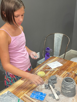 partier building a ceramics coil pot